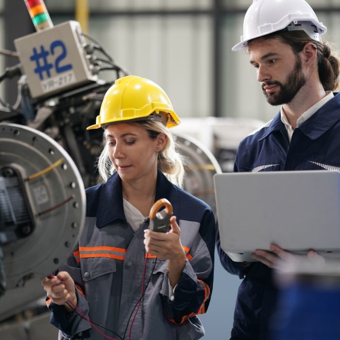 Robotics engineer working on maintenance of robotic arm in factory warehouse. Business technology.